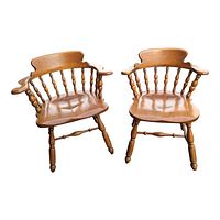 Two mid-century Heywood Wakefield wooden armchairs with spindle backs and curved armrests photographed together.