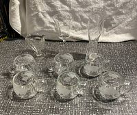 Full set of ten glasses arranged showing seven globe mugs and three unique decorative glasses with world map etching.