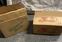 Two original cardboard boxes, one marked 'Princess House' and another marked 'Fantasia', indicating original packaging for glassware items.