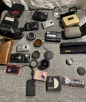 Overhead view of all cameras, lenses, cases, filters and accessories spread on surface