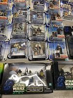 Top view photo showing various Star Wars 'Power of the Force' and 'Trilogy Collection' action figures in original packaging, including Jabba's Skiff Guards set with packaging wear.