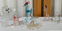 Front view of six glass miniatures including poodle, swan, deer, octopus, elephant, and seahorse, showing relative sizes and details
