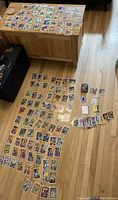 Full view of hundreds of Marvel superhero trading cards spread on the floor and a wooden chest.