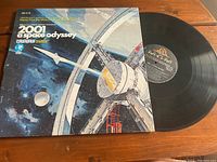 Vinyl record partially pulled out from cover showing the MGM Records label and artwork on the cover depicting a space station and planets.