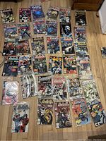 Overview photo showing 35 Punisher comic books spread on a wooden floor, most in plastic protective sleeves, featuring various cover artworks.