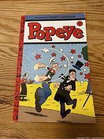 Front cover of Popeye Volume 1 comic book with colorful illustration of Popeye and other characters.