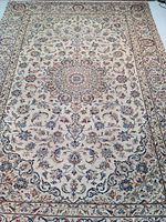 Full front view of beige Persian Kashan rug with central medallion and floral border.