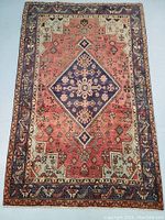 Full view of rectangular rug laid flat showing central medallion and border