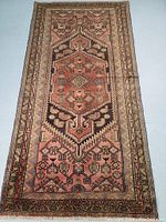 Full view of rug laid flat showing overall geometric pattern, borders and fringe