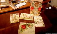Photo showing five antique and handmade cards placed on a wooden surface, highlighting the handmade pop up Valentine card with lace and floral decoration.