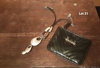 View of both the hammered metal modernist necklace and the black Harrods coin purse showing overall condition and design.