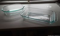Photo showing one oval and one rectangular clear glass Pyrex baking dishes on a surface.