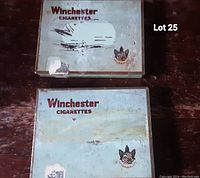 Two rectangular light blue metal Winchester Cigarettes tins showing visible wear and age.