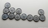 Twelve vintage Canada Shell oil tokens featuring Canadian Prime Ministers laid out.