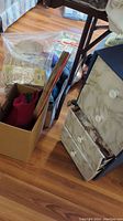 Overall view of crafting supplies including storage drawers and a box with various materials