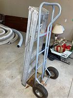 Photo showing the dolly and the folded aluminum step ladder placed upright.