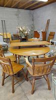 Maple drop leaf oval dining table with six spindle back chairs, aged wear evident.