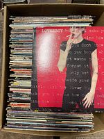 Top-down view of box filled with assorted LP records showing Loverboy record on top.