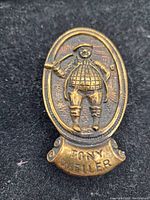 Close-up of the brass knocker face showing Tony Weller figure and name inscription