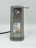 Front angled view of stainless steel electric can opener with label showing brand and features.
