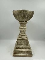 Front view of the heavy vintage pedestal showing its shaped body and stepped base