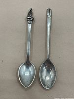 Two vintage sterling silver spoons side by side, showing overall shape and design