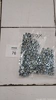 Plastic bag containing 250 hex cap serrated flange nuts.