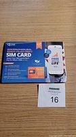 Photo shows boxed QLink Ready-To-Go Free SIM Card kit with promotional material and a printed lot number card.