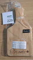 Front side of the cutting board showing the 'Toronto' engraving and maple leaf with brand sticker 'Verdici' in original plastic wrapping.