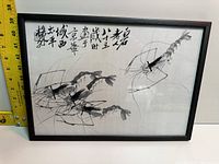 Front view of framed Chinese ink artwork depicting three shrimp with Chinese calligraphy and black wood frame.