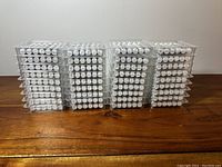 36 clear plastic trays each containing 6 white oil pastels, stacked in 4 columns.