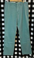 Front view of green Banana Republic chinos hung on hanger showing full length and design