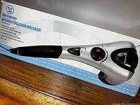 Side view of the box with image of massager showing ergonomic design and control dial.