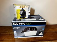 Two boxes stacked: top box is Light It Wireless Porch Light, bottom box is Eaton ALL-PRO LED Area and Wall Light
