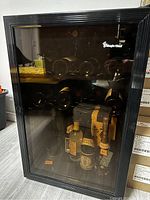 Front view of Smeg wine fridge showing glass door stamped with brand logo, interior shelving with multiple bottles visible inside.