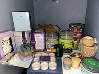 Overall lot of assorted candles and candle accessories showing packaging, loose candles, and candle holders.