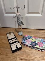 Full view of the jewelry display stand, travel organizer, and floral zippered pouch on the floor