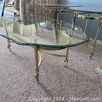 Full view of LaBarge brass and glass coffee table showing thick beveled glass top and ornate brass legs with scrolled caster feet.