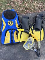Full overview of snorkeling gear including carrying bag, fins, snorkel, and mask placed on outdoor ground