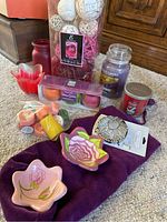 Overview photo showing a group of items including candles, small decorative dishes, potpourri, and a brooch arranged on a purple cloth.