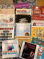 Photo showing collection of 13 vintage LP record albums with titles visible including comedy, pop and orchestral genres.