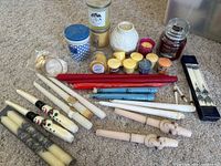 Overview showing multiple tall taper candles, small votive and tealight candles, and decorative candle holders arranged on carpeted floor.