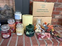 Overview showing 4 Yankee Candle jars, a large off-white pillar candle, green PartyLite pillar candle in fabric wrap, 2 sets of Mason Jar seasonal candle holders (one boxed), and additional candle accessories.