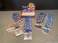 Overall lot showing store wax display box and sealed packs of Desert Storm trading cards distributed on the table in organized groups by card type.
