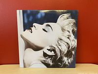 Front cover of Madonna True Blue album showing black and white profile photo of Madonna against a blue background.