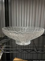 Side view of the clear ABP glass bowl showing detailed pressed pattern and scalloped rim