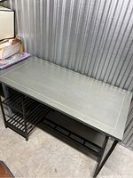 Green rectangular desk with a metal frame and green top in storage unit