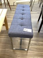 Full top aerial view of the tufted gray fabric bench seat showing the grid pattern upholstery.