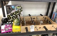 Full lot overview showing foosball table, Magic 8 Ball, Jabba the Hutt toy, magnetic games, and Bounce Off game box