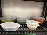 Full view of all bowls and casserole dishes on shelf showing various colors and patterns